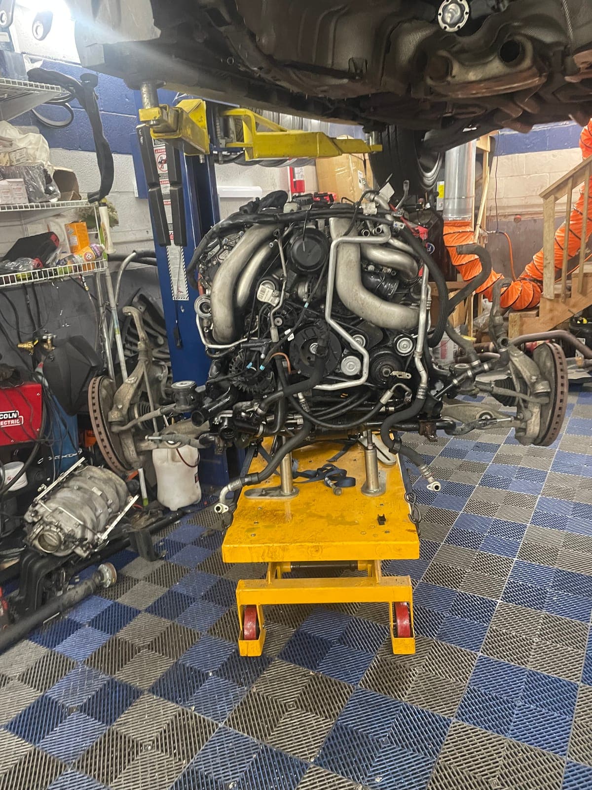 Engine lowered into bay on lift